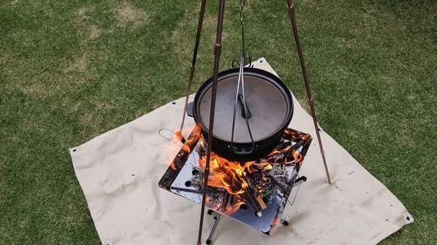 芝の上に敷いたスパッタシートの上で焚き火をしているところ